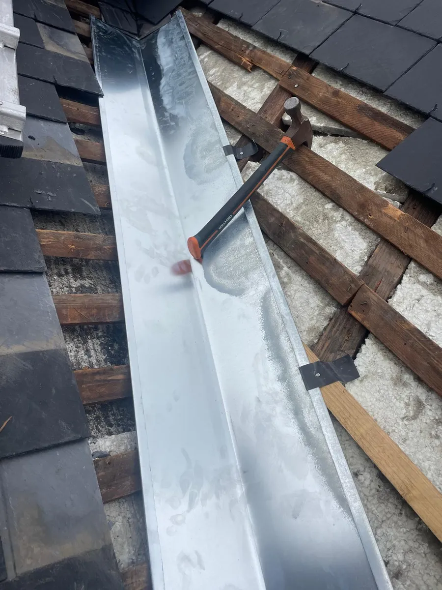 Façonnage d'une noue en zinc sur toiture en ardoise